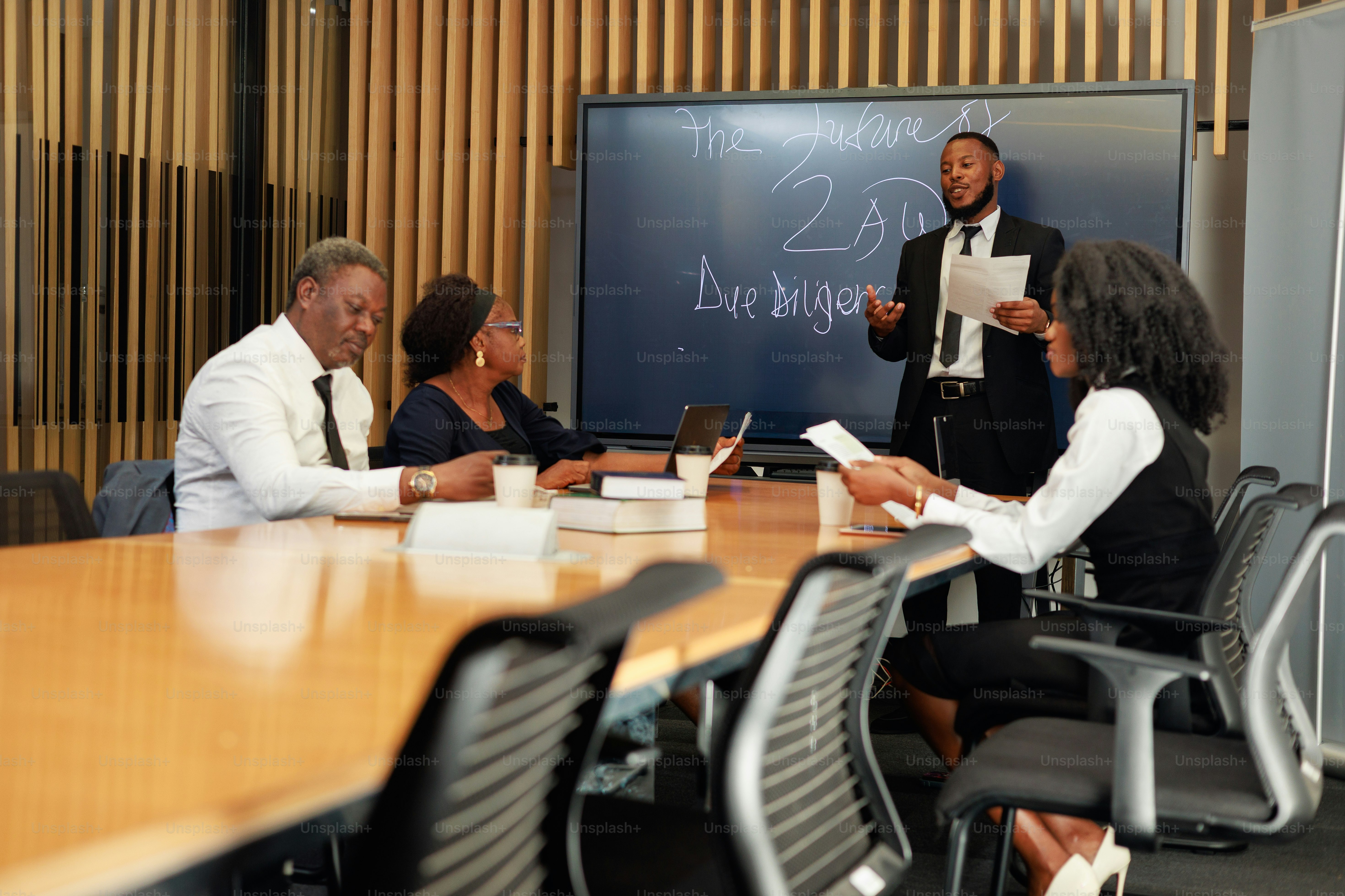 Businesspeople are in a meeting, with a presentation.